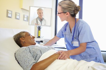 Nurse Talking To Senior Woman In Hospital Room